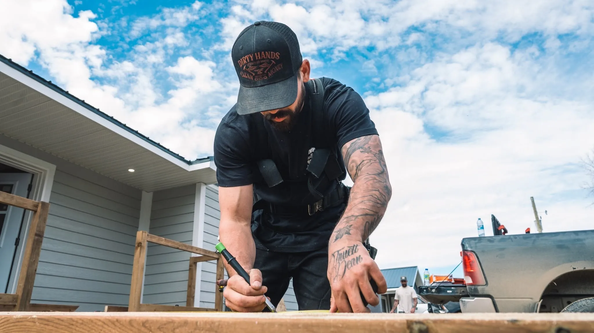 A carpenter marking a board on a job site for a Rega client