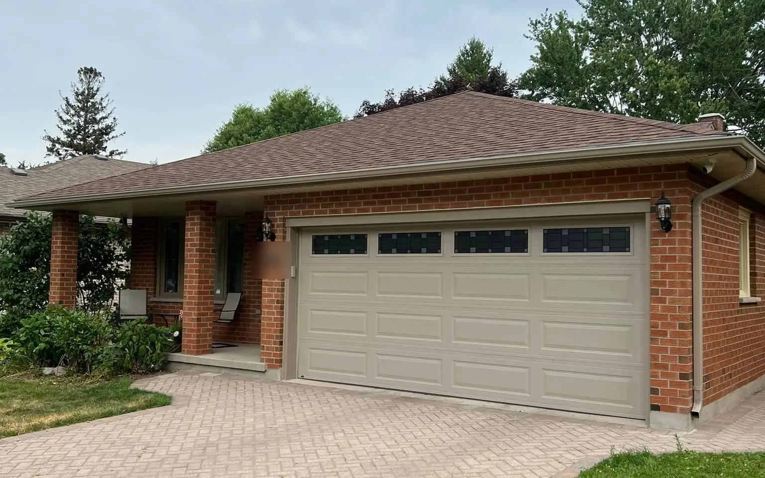 A brick home with a double garage and new eavestroughs, a Rega client job