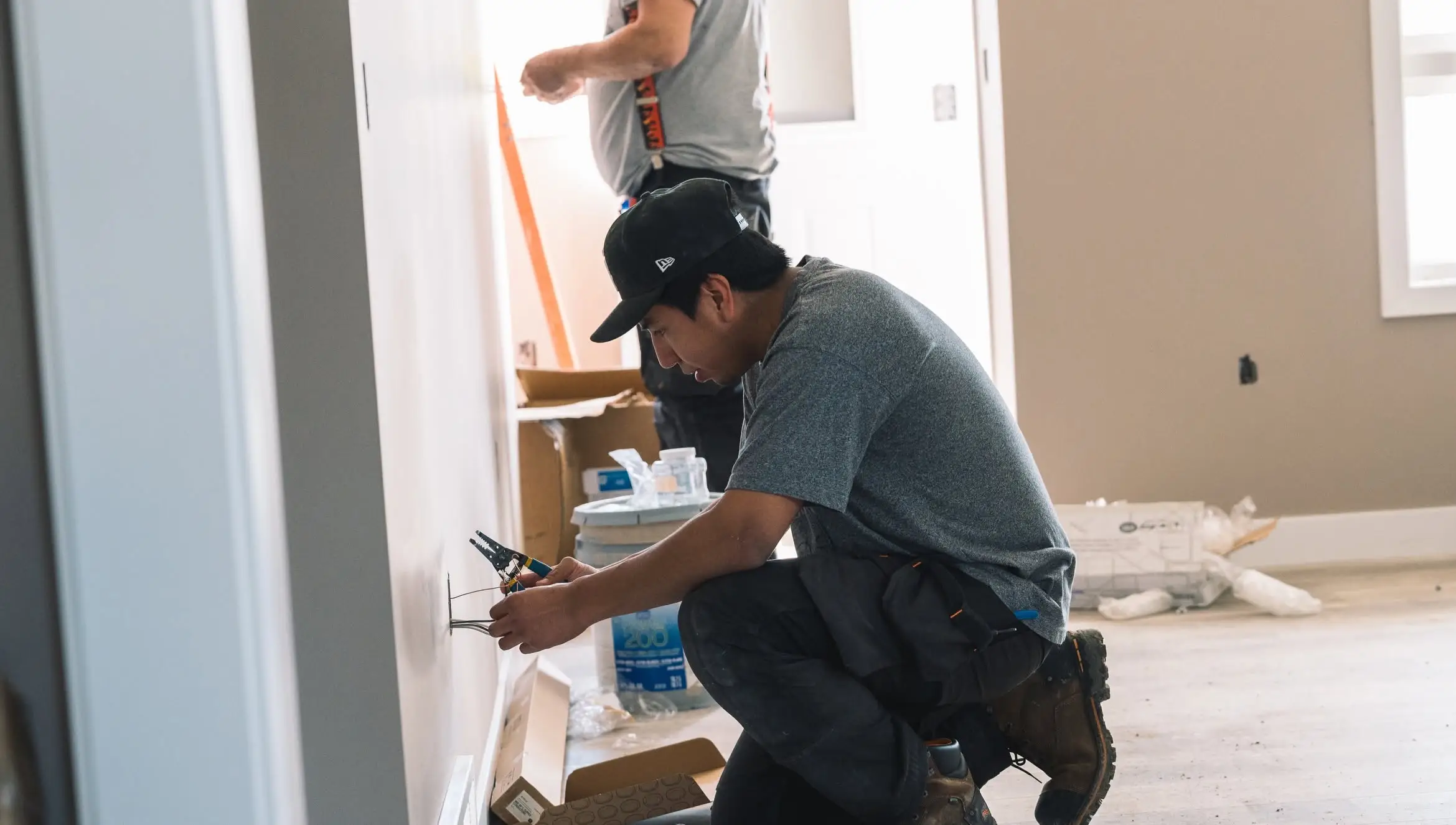Tradespeople working on an electrical installation for a Rega client