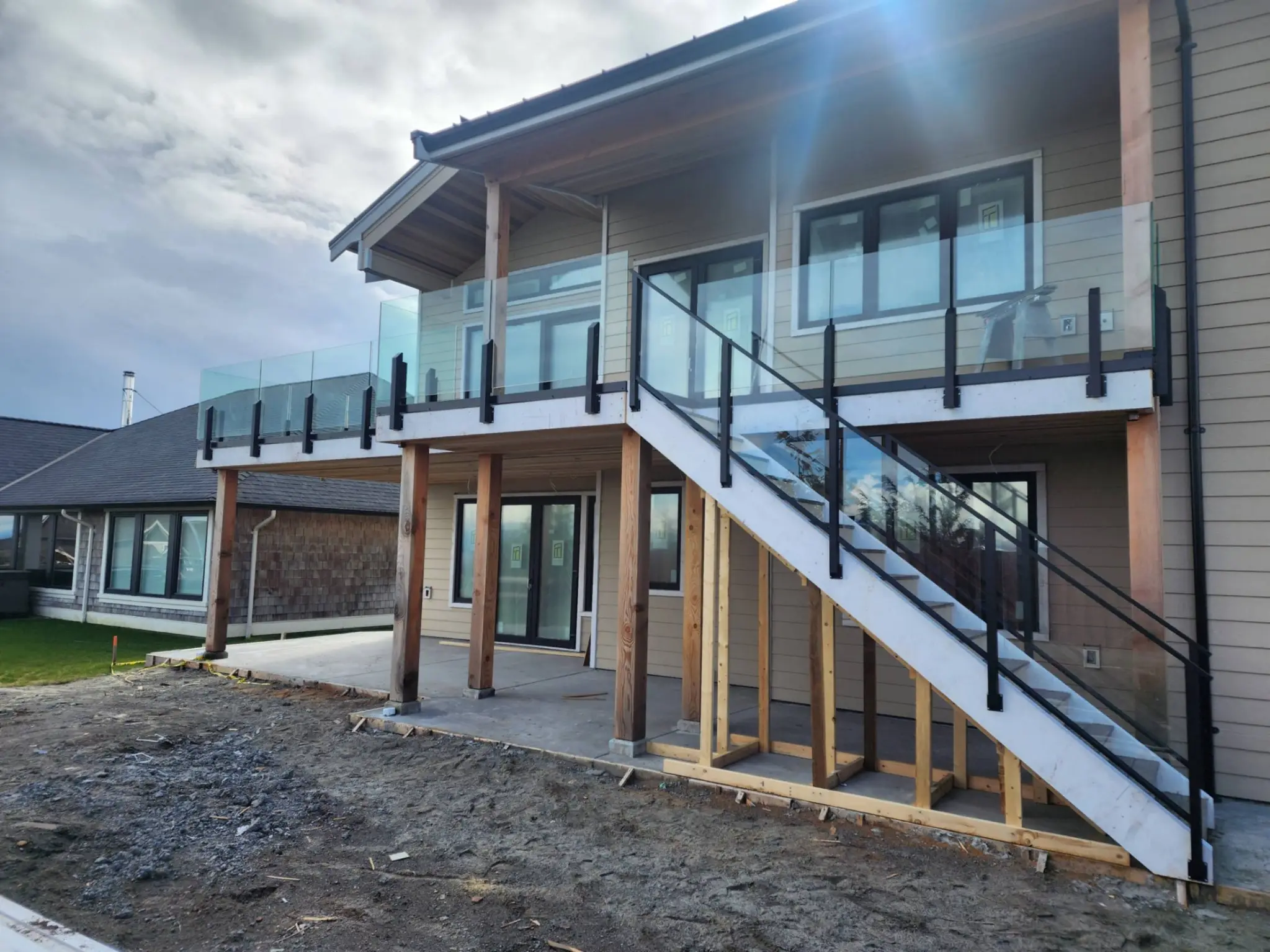 A raised deck with glass railing and stairs built by Siteline Deck and Rail