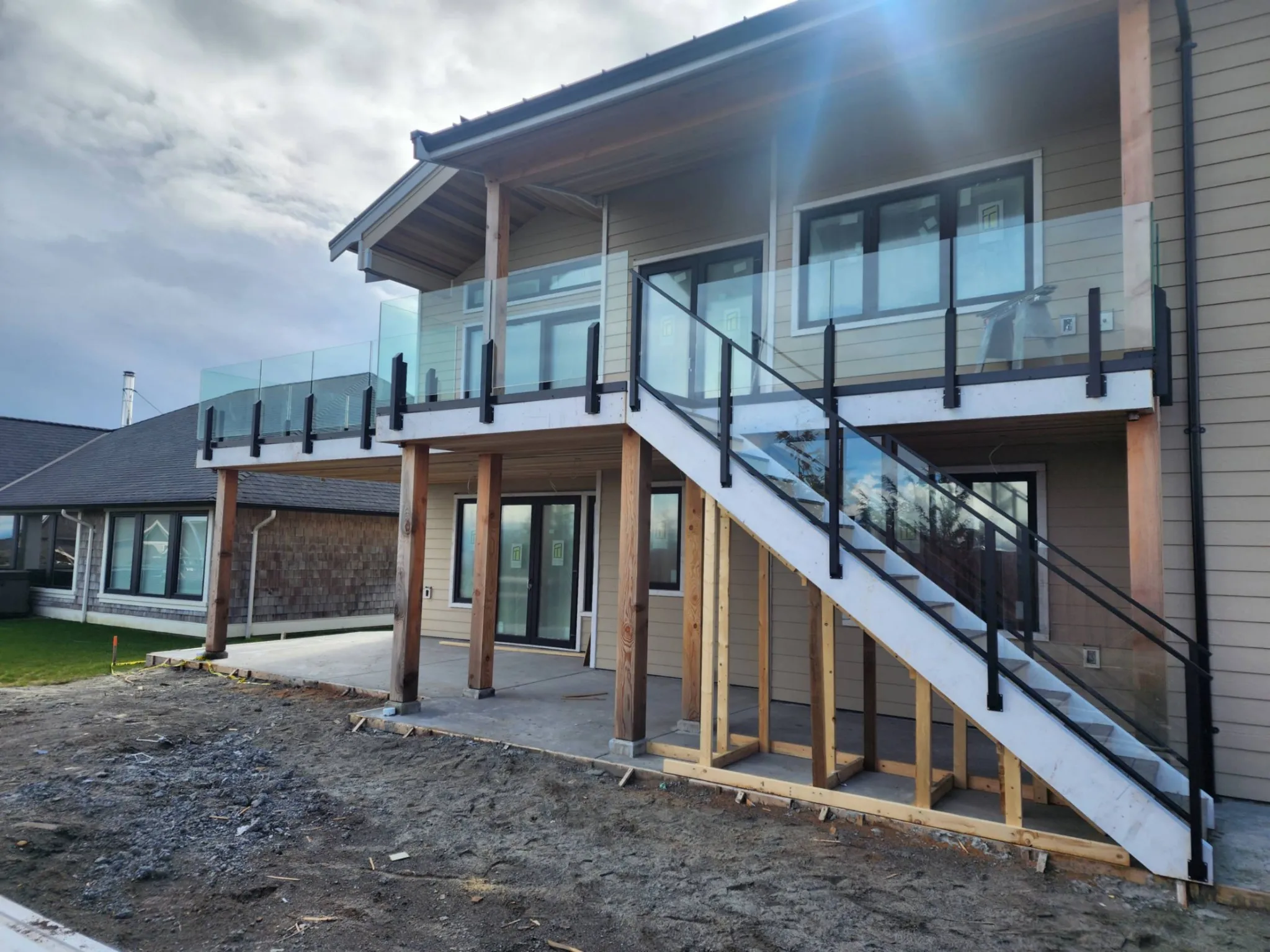 A finished deck and railing on a new house, built by a Rega client